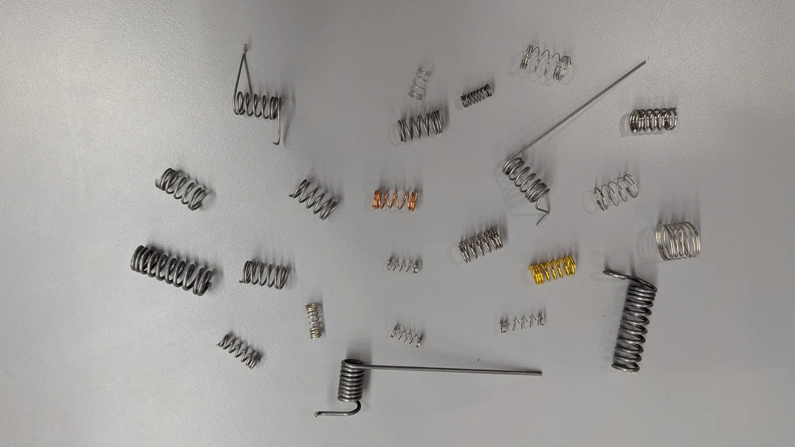 Assortment of metal springs in different diameters, pitches, and wire colors